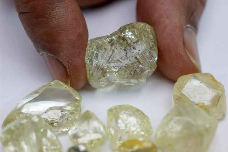 Pravin Kukadia, Director of Eminent Gems LTD, presents different diamonds to AFP during an interview at his office